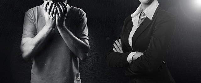 muž, který pláče ruce na obličeji a žena oblečená do kostýmku se založenýma rukama – odmítavý postoj